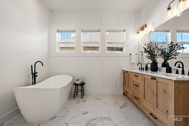 6635 Big Wood Way, Star, ID 83669 - bathroom with marble finish floors, double vanity, a freestanding bath, a decorative wall, and baseboards