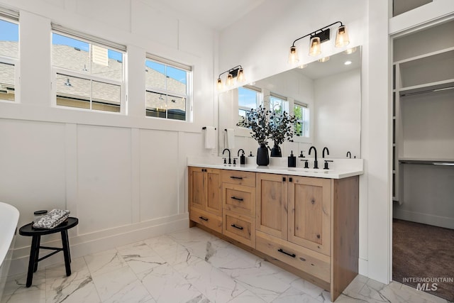 6635 Big Wood Way, Star, ID 83669 - full bath with double vanity, marble finish floors, healthy amount of natural light, a decorative wall, and a freestanding bath