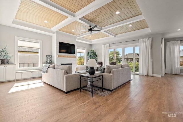 6635 Big Wood Way, Star, ID 83669 - living room with a large fireplace, coffered ceiling, light wood-style flooring, wood ceiling with exposed beams, and a ceiling fan