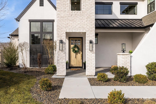 entrance to property with a standing seam roof, metal roof, and stucco siding