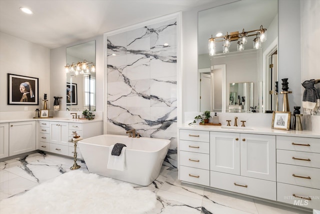 full bathroom featuring a freestanding bath, stone wall, marble finish floor, tile walls, and a sink