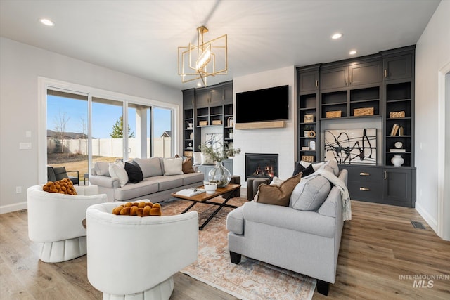 living area with light wood-type flooring, baseboards, a brick fireplace, and visible vents