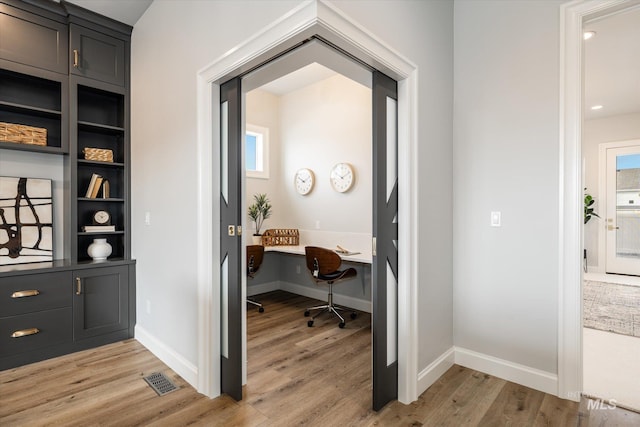 office featuring light wood-type flooring, baseboards, and visible vents