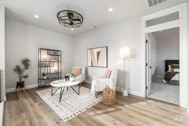 living area featuring recessed lighting, light wood-style floors, visible vents, and baseboards