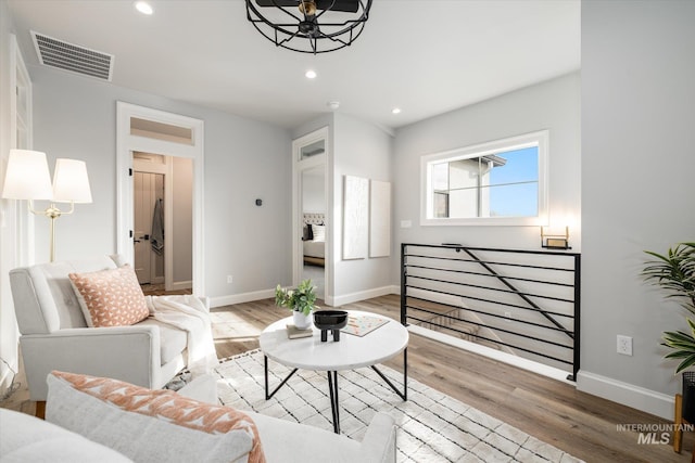 living area featuring recessed lighting, visible vents, light wood finished floors, and baseboards