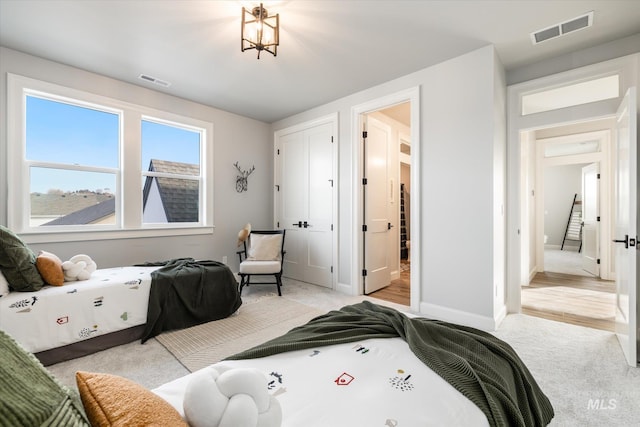 bedroom with visible vents, light carpet, and baseboards