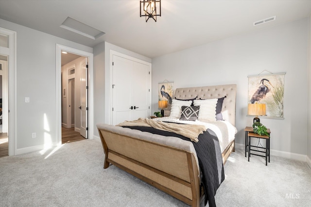 carpeted bedroom with a closet, visible vents, attic access, and baseboards