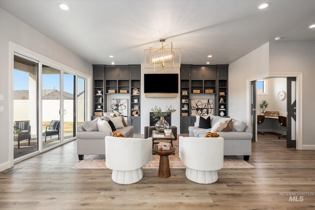 living area featuring recessed lighting, a notable chandelier, wood finished floors, and visible vents