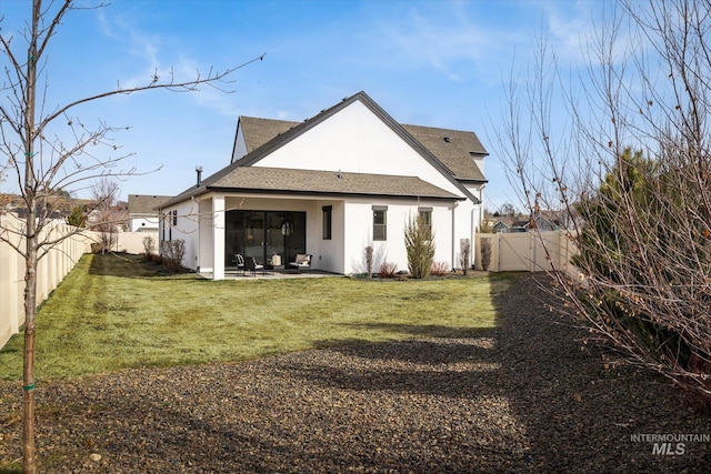 rear view of house featuring a patio, a yard, a fenced backyard, and stucco siding