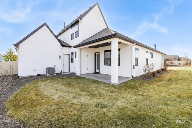 back of house featuring a patio area, stucco siding, a lawn, and fence