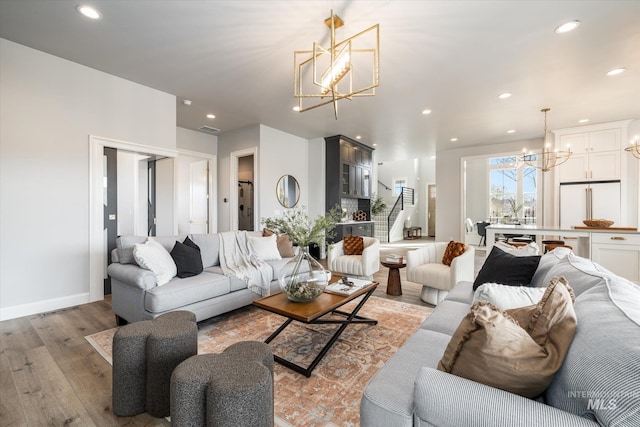 living area with light wood-style flooring, recessed lighting, visible vents, and a chandelier