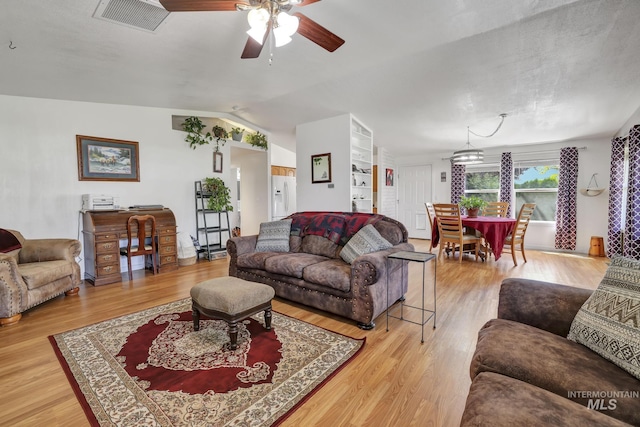 living area with vaulted ceiling, ceiling fan, wood finished floors, and visible vents