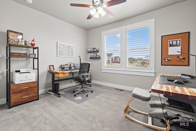 office with light colored carpet, visible vents, baseboards, and a ceiling fan
