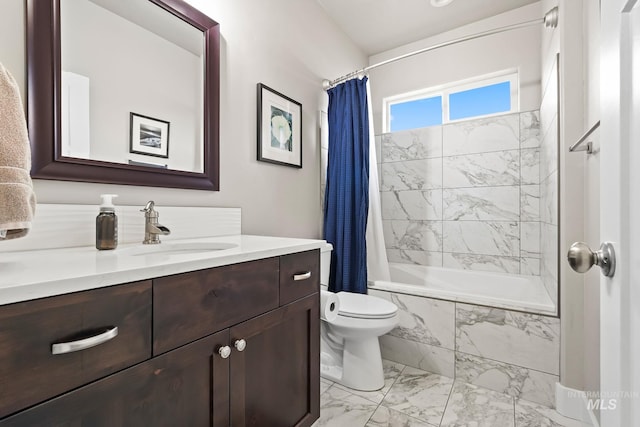full bath with marble finish floor, vanity, tiled shower / bath, and toilet