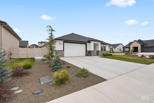 view of front of house featuring fence, stone siding, driveway, a gate, and a garage
