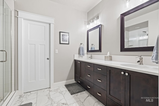 full bathroom with marble finish floor, double vanity, baseboards, and a sink