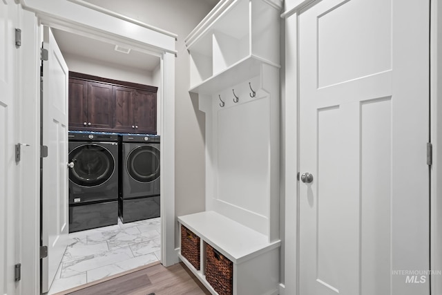 mudroom with marble finish floor, washer and clothes dryer, and visible vents