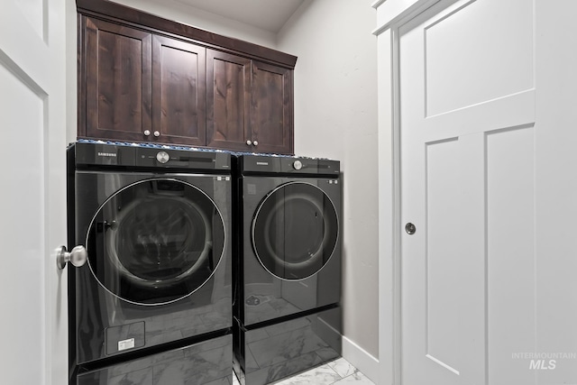 washroom with marble finish floor, cabinet space, baseboards, and washer and dryer