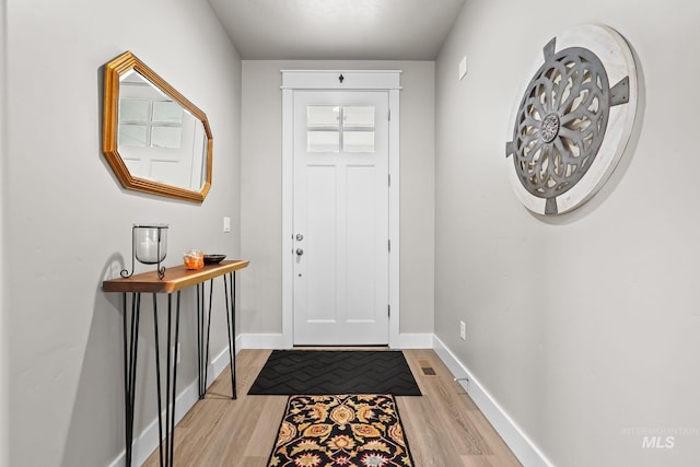foyer entrance with baseboards and light wood-style floors