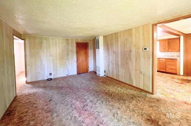 545 Madison St, Twin Falls, ID 83301 - spare room with wood walls, a textured ceiling, carpet flooring, and a heating unit