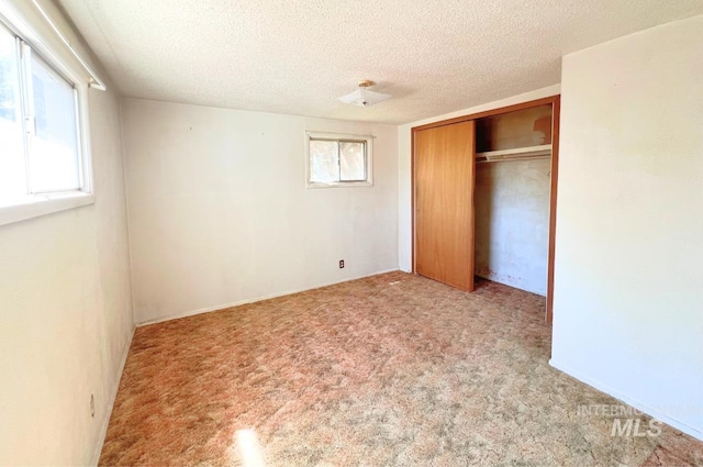 545 Madison St, Twin Falls, ID 83301 - unfurnished bedroom with multiple windows, a closet, a textured ceiling, and carpet flooring