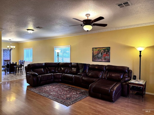 3485 N Chatterton Ave, Boise, ID 83713 - living room with a chandelier, wood finished floors, crown molding, a textured ceiling, and a ceiling fan
