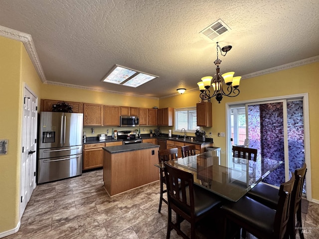 3485 N Chatterton Ave, Boise, ID 83713 - kitchen featuring stainless steel appliances, ornamental molding, a chandelier, dark countertops, and a textured ceiling