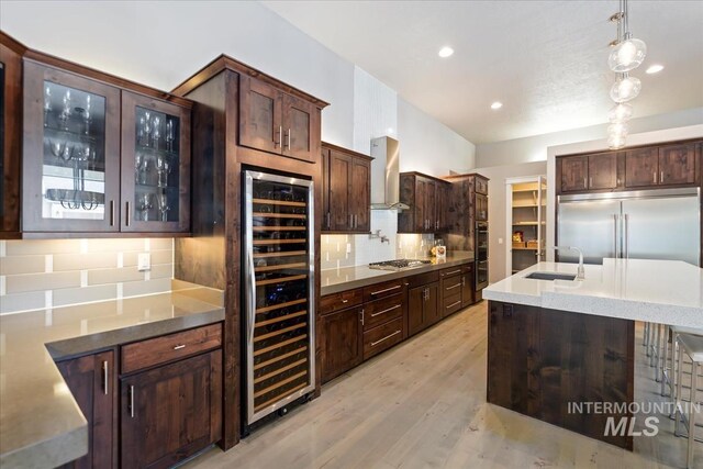 4307 W Briar Rock Ct, Eagle, ID 83616 - kitchen featuring wine cooler, appliances with stainless steel finishes, wall chimney exhaust hood, a sink, and tasteful backsplash