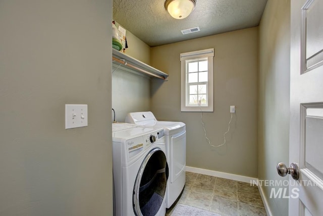 laundry area featuring visible vents, baseboards, laundry area, independent washer and dryer, and a textured ceiling