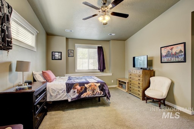 carpeted bedroom with visible vents, baseboards, a textured ceiling, and ceiling fan