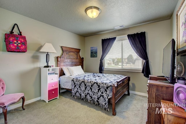 bedroom with visible vents, baseboards, light colored carpet, and a textured ceiling