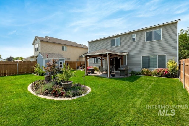 rear view of house featuring an outbuilding, a fenced backyard, a gazebo, a patio area, and a lawn