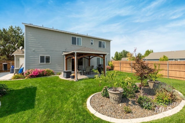 rear view of house featuring a gazebo, a patio, a lawn, and a fenced backyard