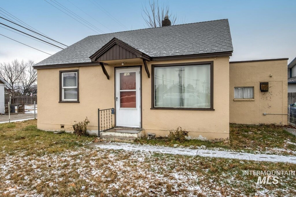 107 E 5th St, Emmett, ID 83617 - bungalow with roof with shingles, stucco siding, and fence