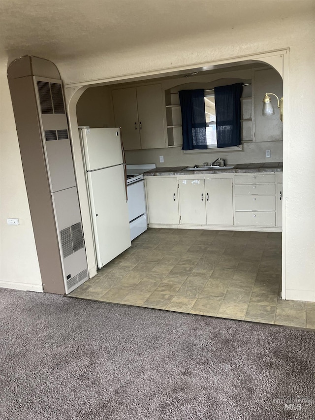 107 E 5th St, Emmett, ID 83617 - kitchen featuring white appliances, a sink, white cabinets, arched walkways, and a heating unit