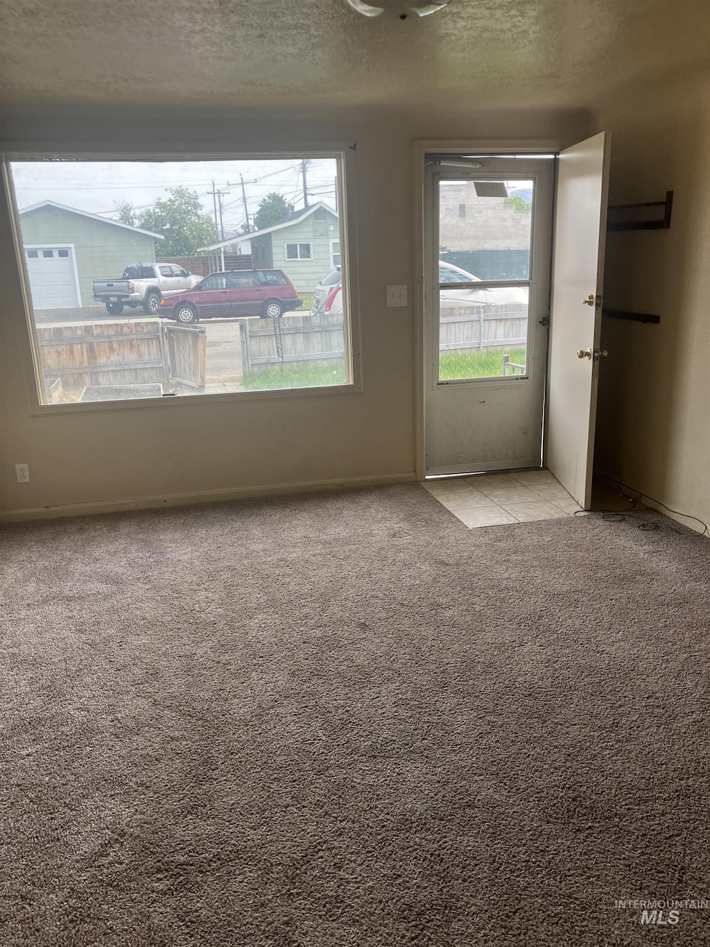 107 E 5th St, Emmett, ID 83617 - unfurnished room with healthy amount of natural light, light colored carpet, baseboards, and a textured ceiling