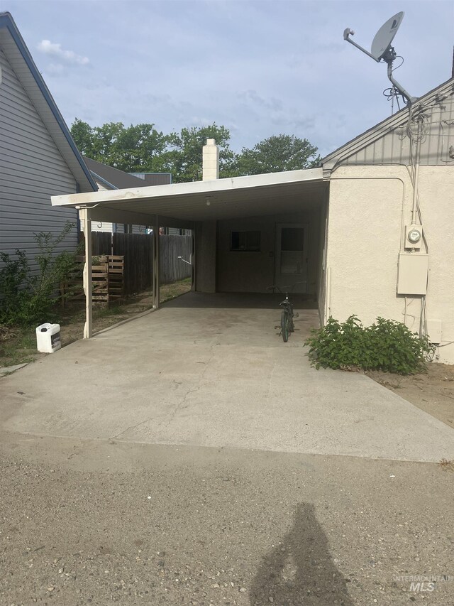 107 E 5th St, Emmett, ID 83617 - view of parking with fence, a carport, and concrete driveway