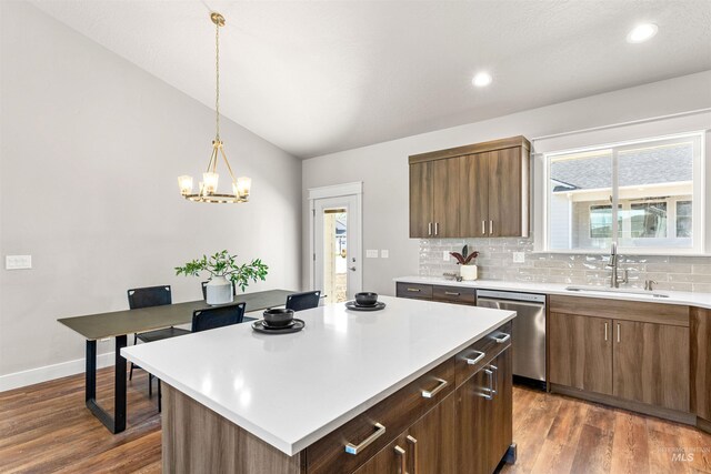 kitchen featuring a sink, light countertops, decorative backsplash, stainless steel dishwasher, and dark wood-style floors