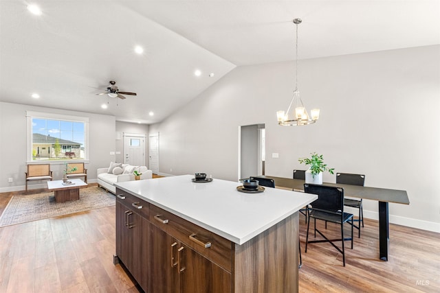 kitchen featuring light countertops, baseboards, light wood-type flooring, and a center island