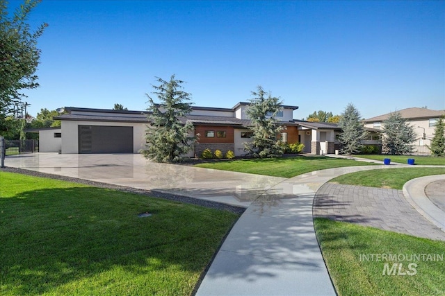 prairie-style home with a front lawn and a garage