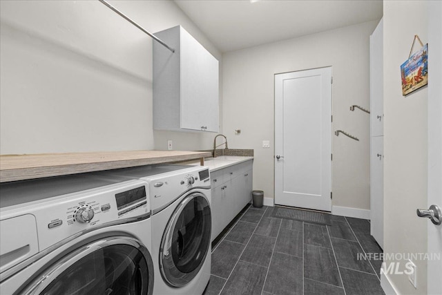 clothes washing area with cabinets, sink, and washing machine and clothes dryer