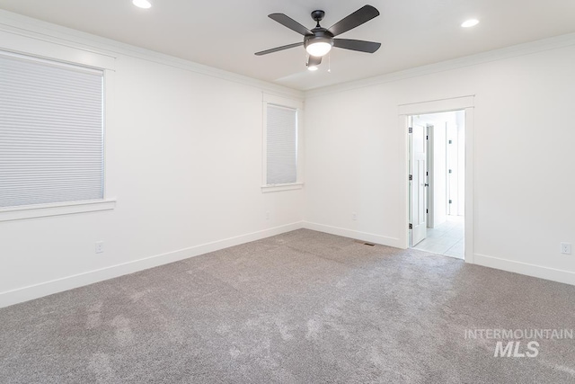 carpeted empty room featuring crown molding and ceiling fan