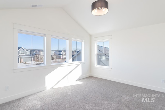 carpeted spare room with lofted ceiling