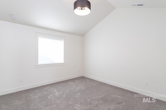 unfurnished room with vaulted ceiling and carpet