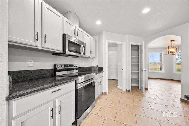 25022 Tumbleweed, Middleton, ID 83644 - kitchen with appliances with stainless steel finishes, arched walkways, recessed lighting, white cabinets, and baseboards