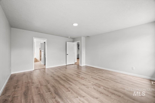25022 Tumbleweed, Middleton, ID 83644 - unfurnished bedroom featuring wood finished floors, baseboards, a textured ceiling, and connected bathroom