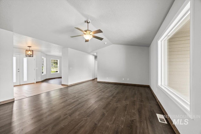 25022 Tumbleweed, Middleton, ID 83644 - unfurnished living room with dark wood-style flooring, ceiling fan, lofted ceiling, a textured ceiling, and baseboards