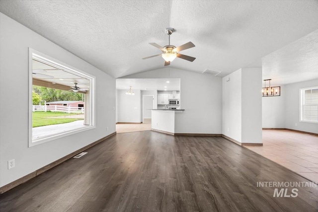 25022 Tumbleweed, Middleton, ID 83644 - unfurnished living room with a chandelier, a ceiling fan, lofted ceiling, wood finished floors, and a textured ceiling