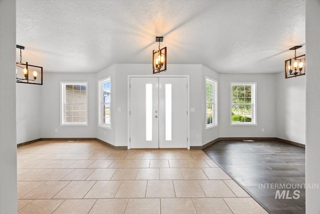25022 Tumbleweed, Middleton, ID 83644 - tiled entryway featuring a chandelier, a textured ceiling, and baseboards