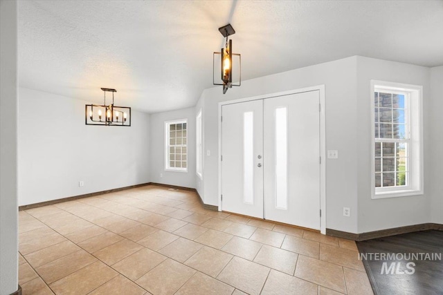 25022 Tumbleweed, Middleton, ID 83644 - foyer featuring a chandelier, baseboards, and light tile patterned floors